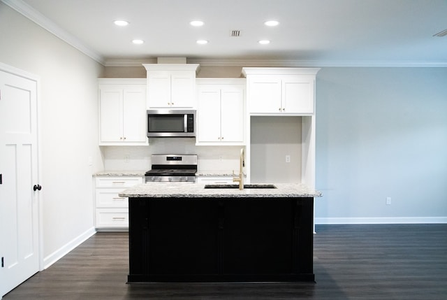 kitchen with white cabinetry, sink, stainless steel appliances, and a center island with sink