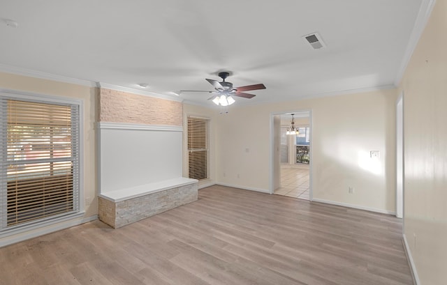 unfurnished living room with ceiling fan with notable chandelier, light hardwood / wood-style floors, and crown molding