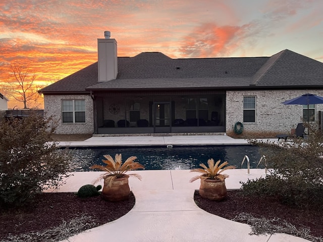 pool at dusk featuring a patio