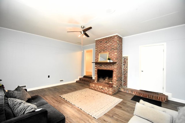 145 Deerpath St, Ozark, AL 36360 - living area with a ceiling fan, wood finished floors, a brick fireplace, and baseboards