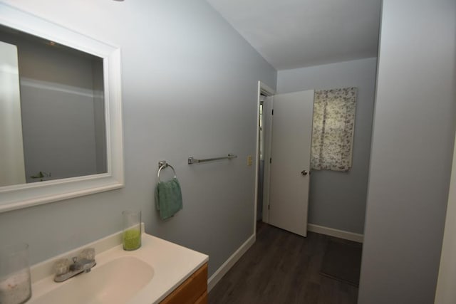 bathroom featuring baseboards, wood finished floors, and vanity