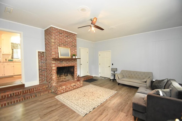 145 Deerpath St, Ozark, AL 36360 - living area featuring a ceiling fan, light wood finished floors, a fireplace, and crown molding