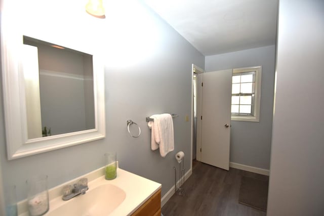 bathroom featuring baseboards, wood finished floors, and vanity