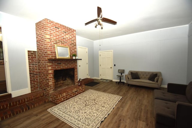 living room featuring a fireplace, baseboards, ceiling fan, and wood finished floors