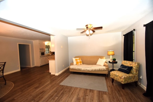 living area with dark wood finished floors, baseboards, and a ceiling fan