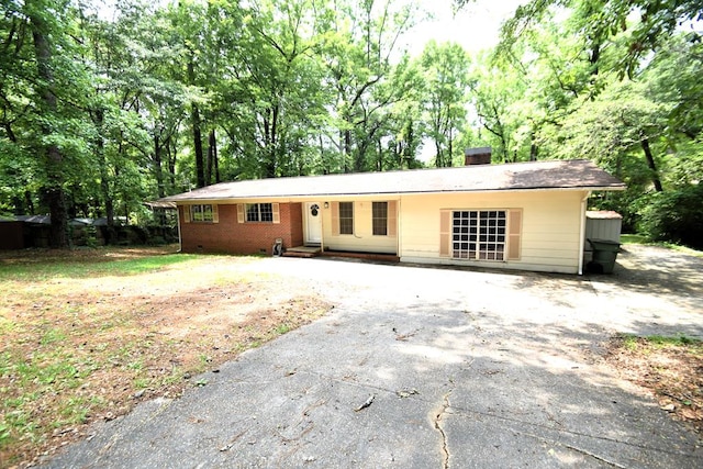 145 Deerpath St, Ozark, AL 36360 - ranch-style home with driveway, a chimney, and view of wooded area