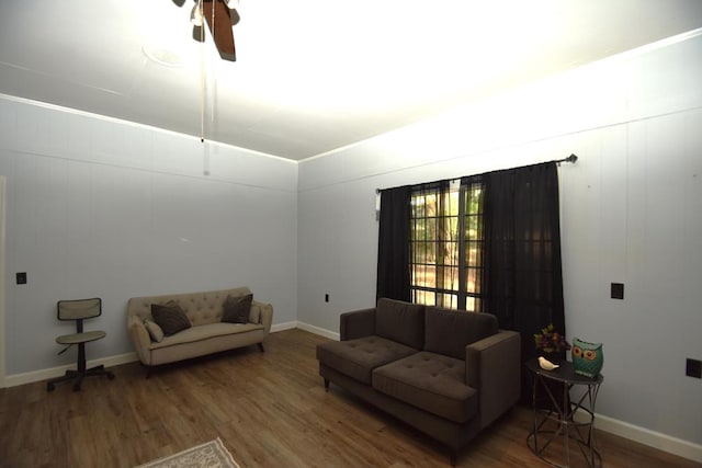 living area featuring baseboards, wood finished floors, and a ceiling fan