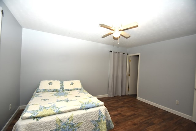 bedroom featuring baseboards, a ceiling fan, and dark wood-style flooring