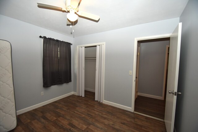 unfurnished bedroom with baseboards, a closet, a ceiling fan, and dark wood finished floors