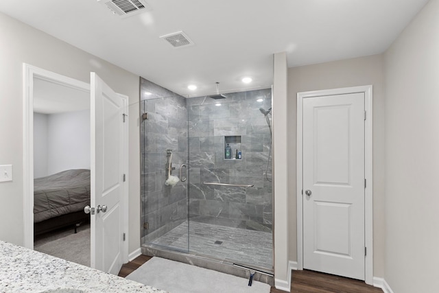 bathroom featuring wood-type flooring and an enclosed shower