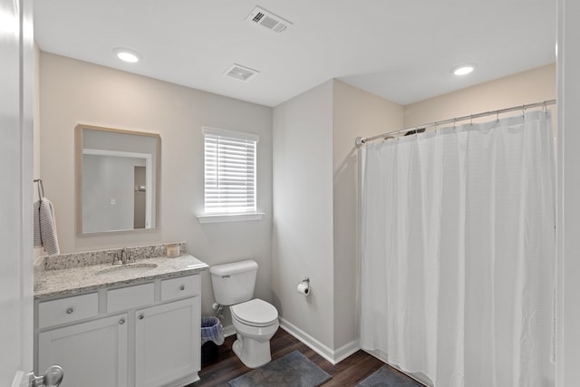 bathroom with toilet, hardwood / wood-style floors, and vanity