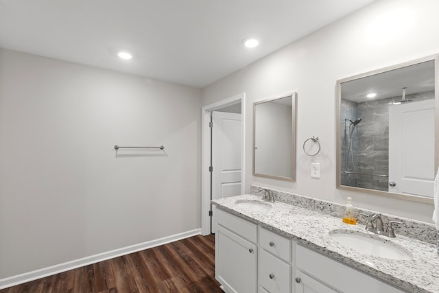 bathroom featuring vanity, hardwood / wood-style floors, and tiled shower