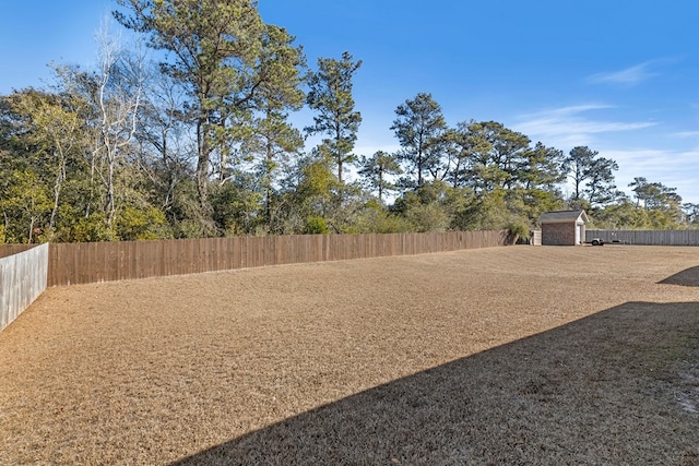 view of yard featuring an outbuilding, a storage shed, and a fenced backyard