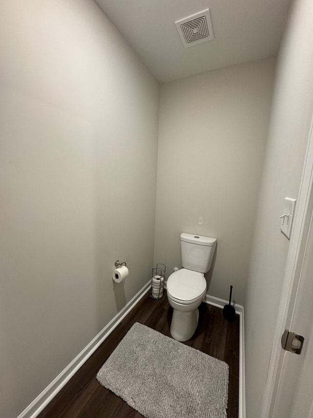 bathroom with visible vents, toilet, baseboards, and wood finished floors