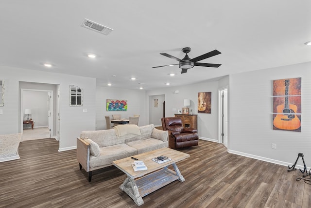 living room featuring ceiling fan and dark hardwood / wood-style floors