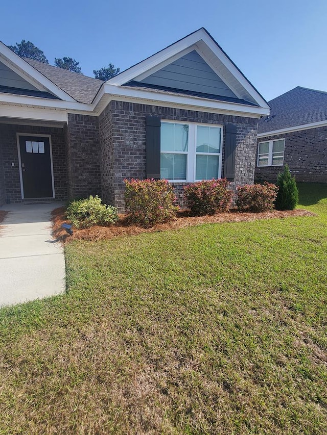 view of front of home with brick siding and a front yard