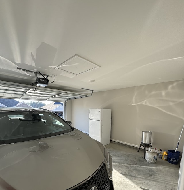 garage featuring a garage door opener and freestanding refrigerator