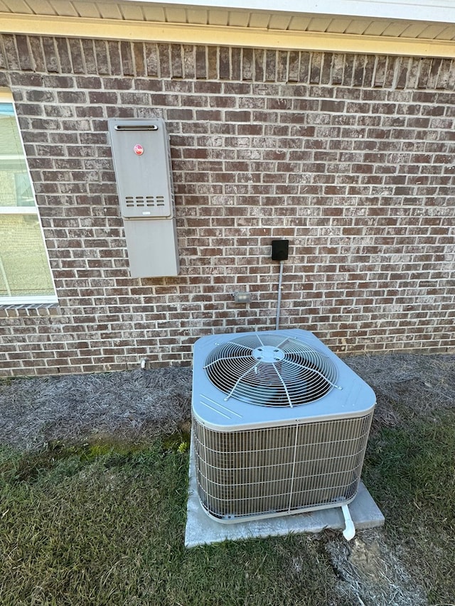exterior details with central air condition unit and brick siding
