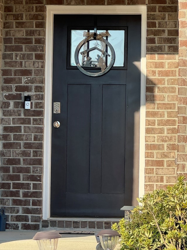 view of exterior entry featuring brick siding