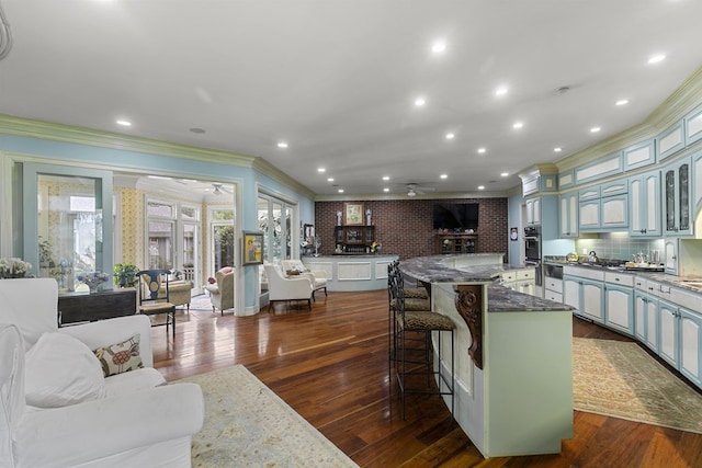 109 Royal Highlands Ln, Dothan, AL 36305 - kitchen featuring ceiling fan, ornamental molding, glass insert cabinets, a kitchen breakfast bar, and a large island