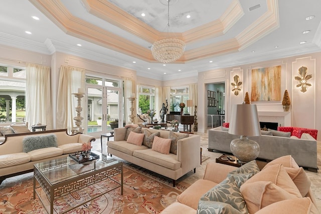 109 Royal Highlands Ln, Dothan, AL 36305 - living room featuring a raised ceiling, a chandelier, crown molding, and a fireplace