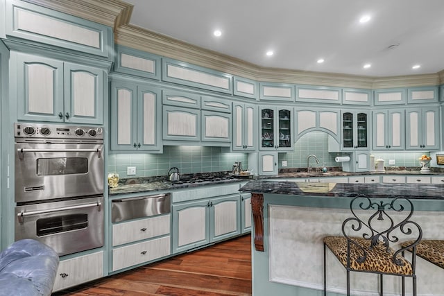 109 Royal Highlands Ln, Dothan, AL 36305 - kitchen with stainless steel appliances, a warming drawer, a kitchen breakfast bar, tasteful backsplash, and dark stone counters