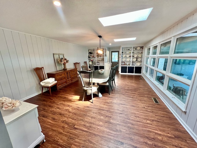 601 6th Ave, Ashford, AL 36312 - dining area featuring a skylight, dark wood-style flooring, built in shelves, and a textured ceiling