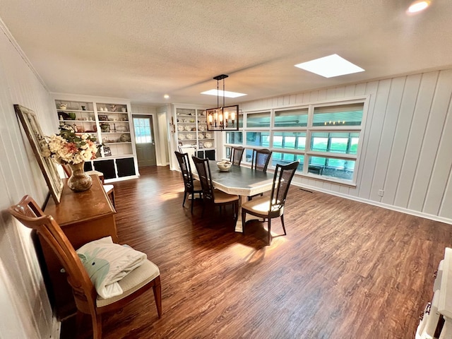 601 6th Ave, Ashford, AL 36312 - dining space with a textured ceiling, dark wood-type flooring, built in features, a skylight, and a chandelier