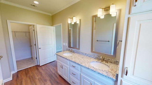 bathroom featuring vanity, wood-type flooring, and ornamental molding