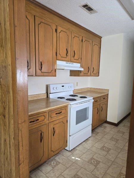 kitchen featuring a textured ceiling and white electric stove