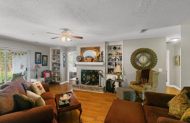 303 Denise St, Dothan, AL 36305 - living area featuring a ceiling fan, a textured ceiling, wood finished floors, a brick fireplace, and baseboards