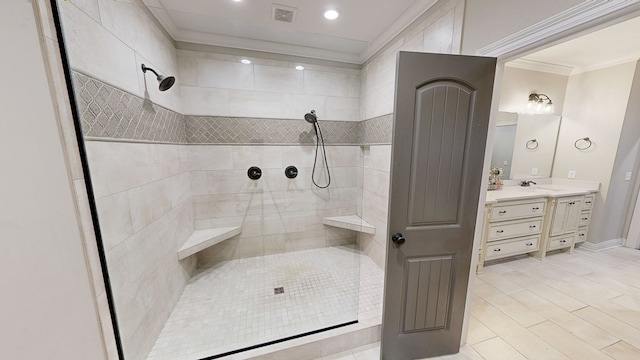 bathroom with vanity, a tile shower, and crown molding