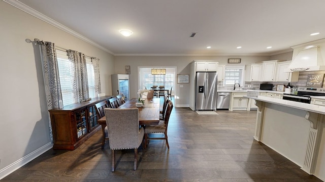 dining room featuring dark hardwood / wood-style floors, sink, and crown molding