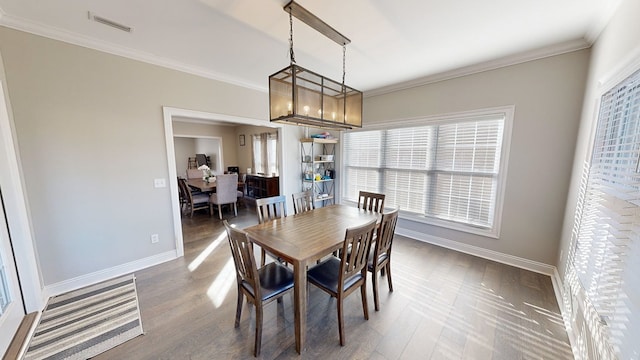 dining space with dark hardwood / wood-style flooring, a chandelier, and ornamental molding