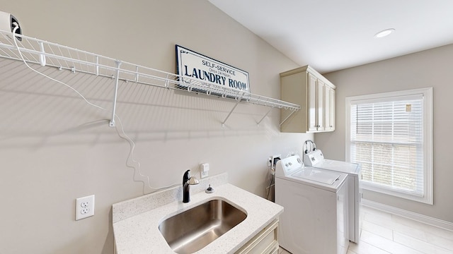 laundry room with cabinets, independent washer and dryer, and sink