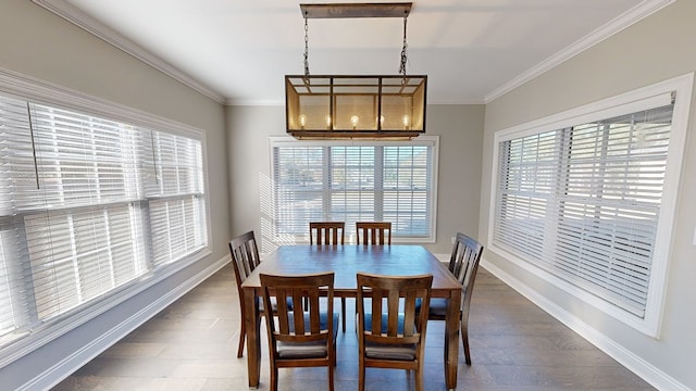 dining space with dark hardwood / wood-style flooring, an inviting chandelier, and ornamental molding