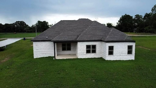 5120 Judge Logue Rd, Newton, AL 36352 - rear view of house featuring a lawn, a patio area, brick siding, and a shingled roof