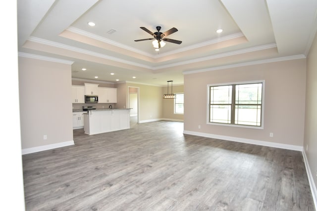 5120 Judge Logue Rd, Newton, AL 36352 - unfurnished living room with a tray ceiling, ceiling fan, wood finished floors, crown molding, and recessed lighting