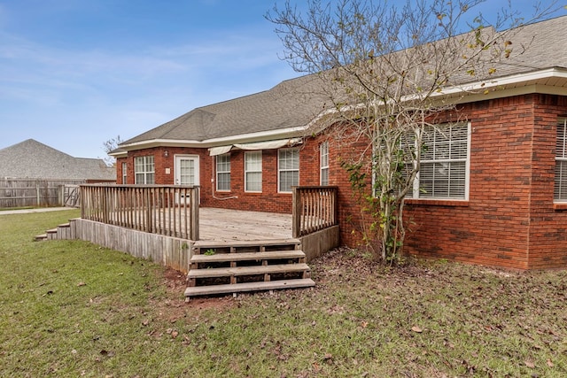 rear view of house featuring a yard and a deck