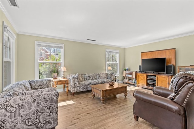 living area with ornamental molding, light wood finished floors, and visible vents