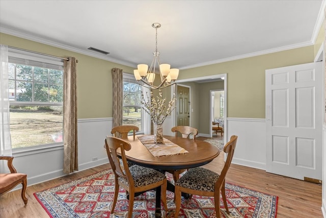 dining room featuring light wood finished floors, plenty of natural light, and visible vents