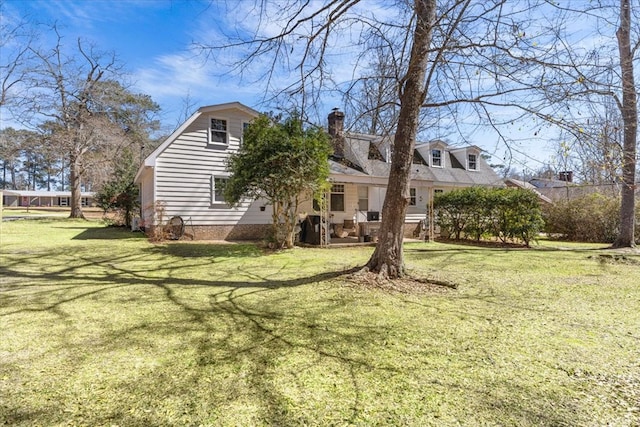 exterior space featuring a front lawn and a chimney