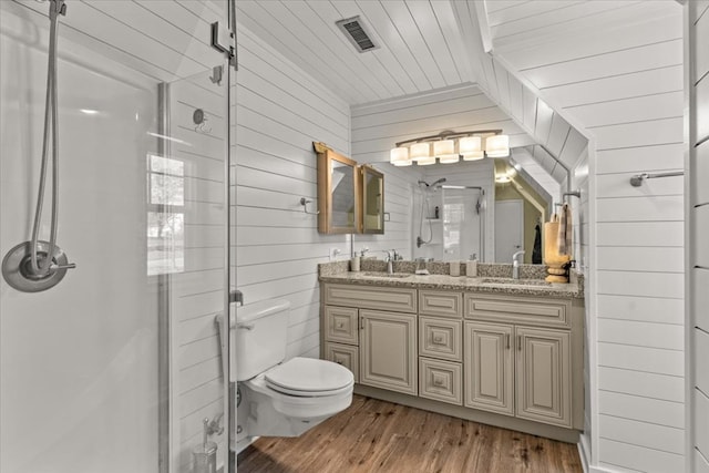 full bath featuring wooden walls, a sink, visible vents, and a shower stall