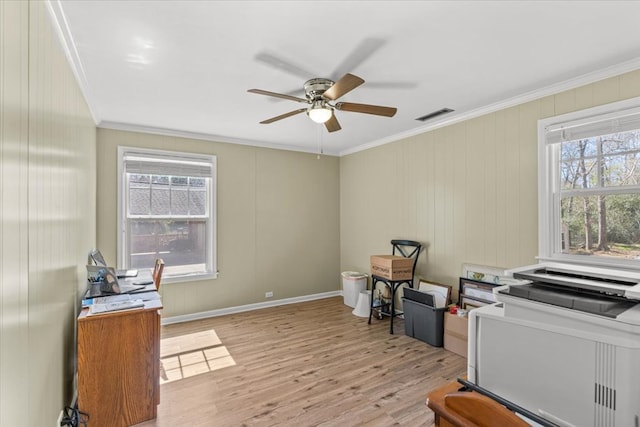 office space with light wood-type flooring, a healthy amount of sunlight, visible vents, and ornamental molding