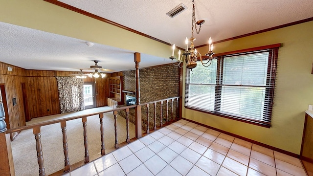 interior space featuring crown molding, a textured ceiling, and visible vents