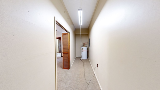 hall with baseboards, light carpet, and water heater