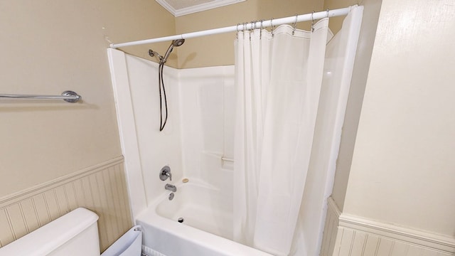 bathroom featuring crown molding, shower / bath combo, wainscoting, and toilet