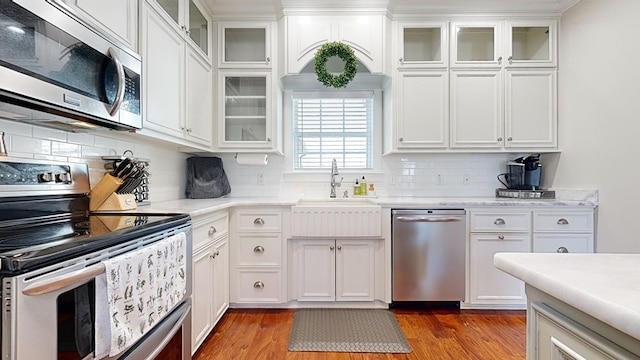 kitchen featuring tasteful backsplash, dark wood-type flooring, white cabinets, and stainless steel appliances