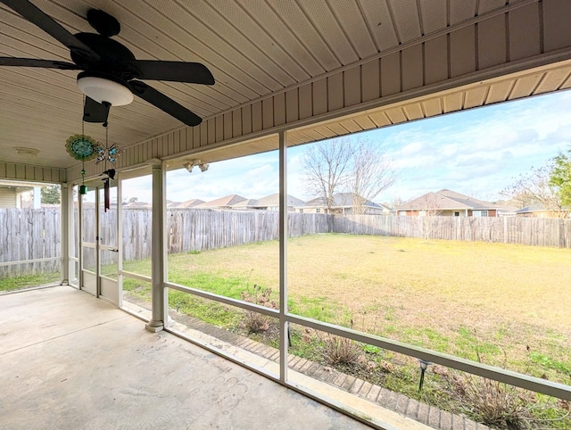 unfurnished sunroom with ceiling fan