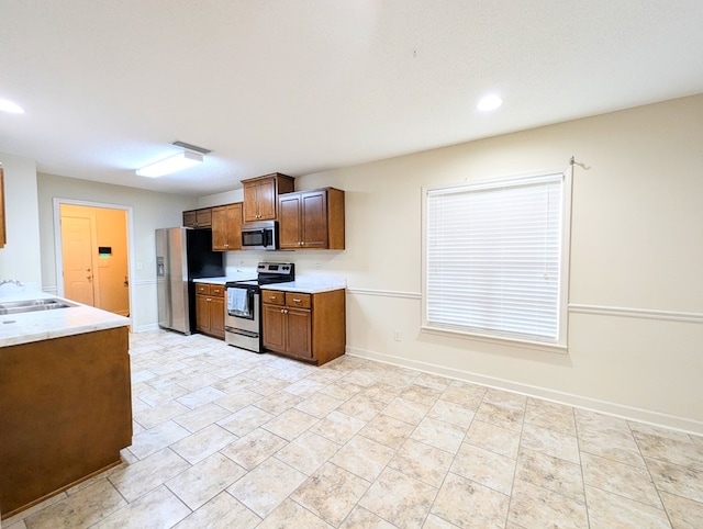 kitchen with appliances with stainless steel finishes, visible vents, a sink, and baseboards